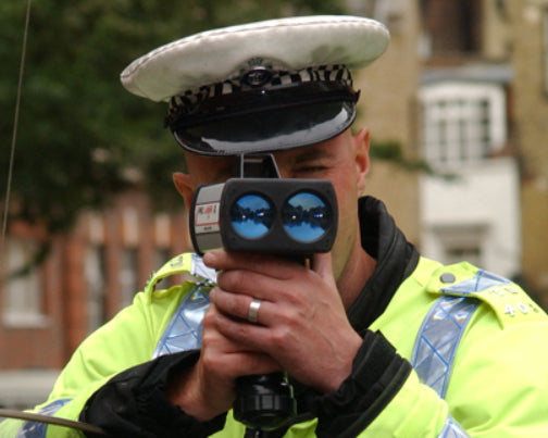 Policeman using a police laser speed trap gun